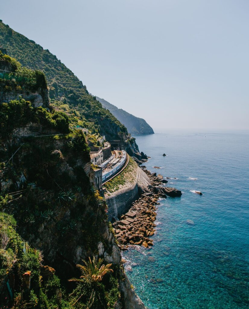 vertical shot of green mountains by the body of an ocean